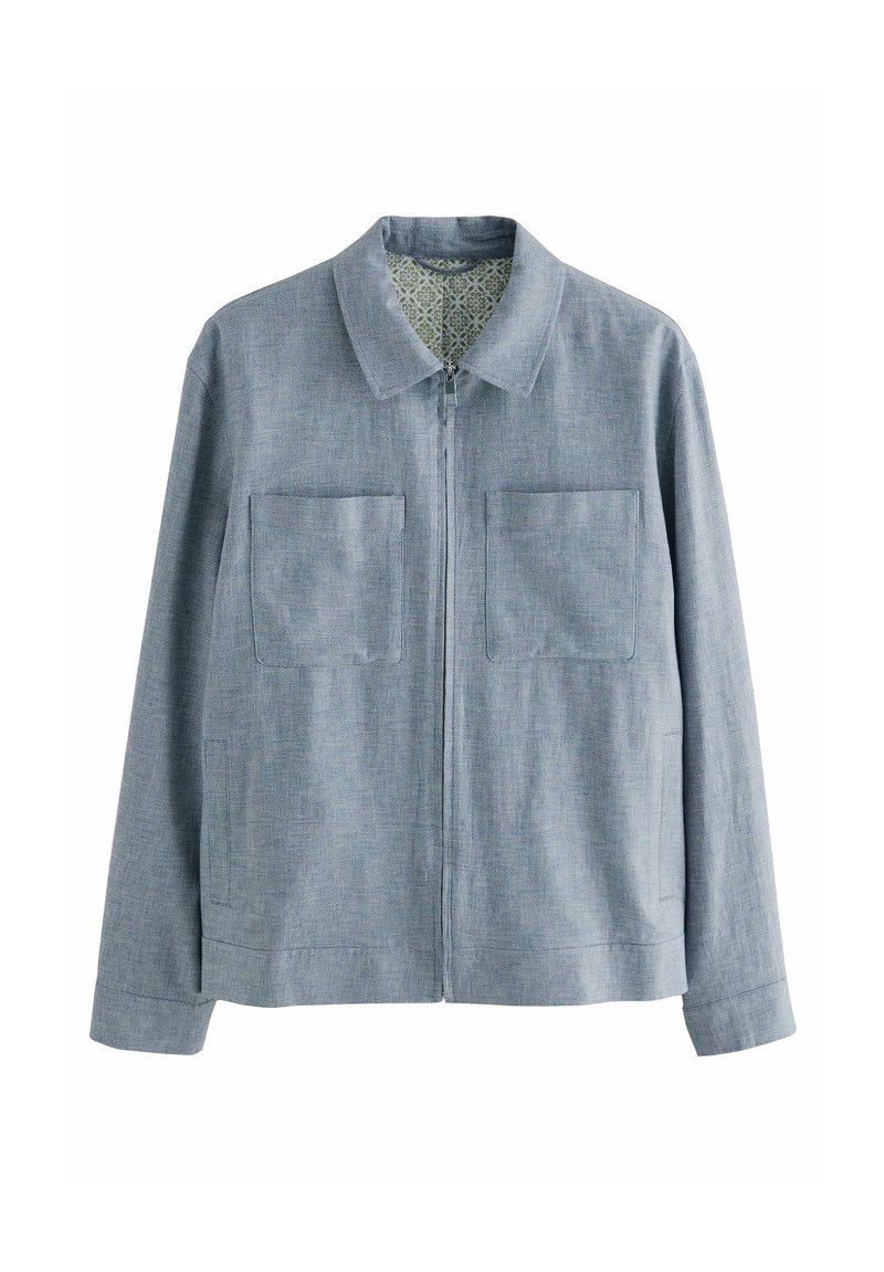 Chaqueta de color azul claro con cremallera, que presenta un cuello con solapa, dos bolsillos frontales y un forro interior texturizado con un patrón floral.