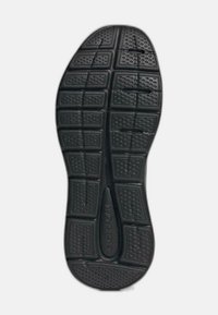 Semelle de chaussure en caoutchouc noir avec une texture antidérapante, présentant des motifs rectangulaires et circulaires, conçue pour la traction et la durabilité.