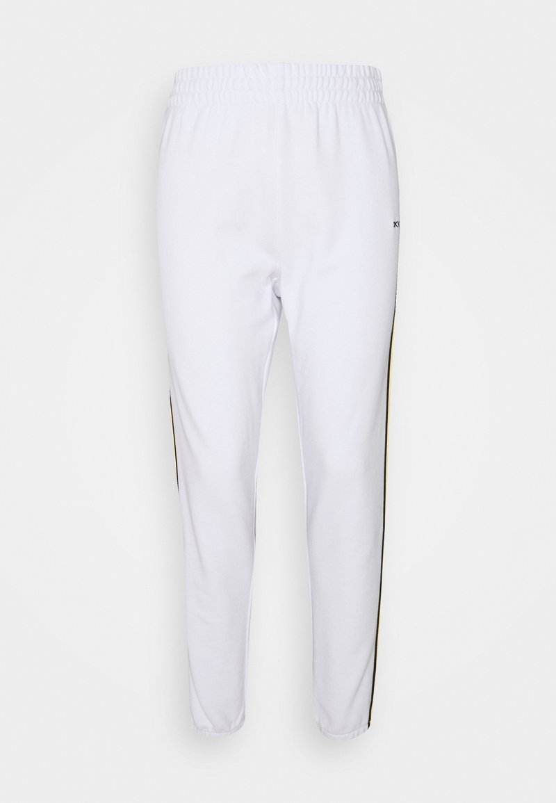 Bílé joggingové kalhoty s elastickým pasem, s černými a žlutými bočními proužky. Vyrobené z měkké tkaniny s hladkým povrchem.