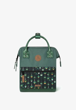 Green textured bag with a patterned front featuring hanging plants, dual handles, and a zippered compartment at the base. Logo tag visible.