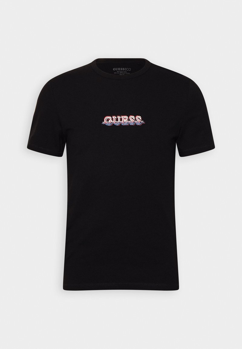 Camiseta de algodón negra con mangas cortas. Presenta un logo central en blanco y rojo de "GUESS" con un efecto de sombra. Diseño estándar de cuello redondo.