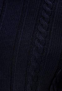 Pull en tricot bleu marine avec un motif en relief texturé et des détails en torsades au centre, doté d'une finition en fil doux et épais.