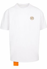 Hvid bomulds t-shirt med korte ærmer, rund hals, med et lille rundt logo i brun og et orange mærke nederst til venstre.