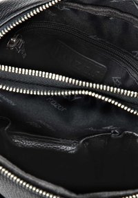 Borsa nera con zip interna, dotata di molteplici tasche; tessuto texturizzato; logo impresso sulla fodera; dettagli in metallo argentato sulla zip.