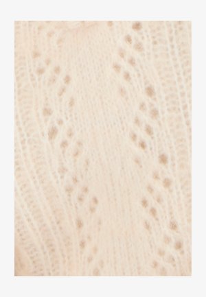 Pullover lavorato a maglia di un leggero beige, caratterizzato da un delicato motivo in pizzo con texture sollevate e piccoli accenti a forma di punto distribuiti su tutto il tessuto.