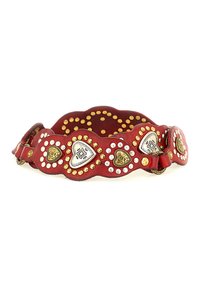 Cintura in pelle rossa con bordi scallopati, decorata con borchie d'oro e d'argento, dettagli metallici a forma di cuore e finitura texturizzata.