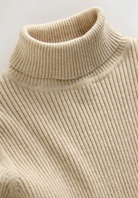 Pulover bej cu guler înalt, cu model texturat și dungi verticale, realizat dintr-un material moale și elastic.