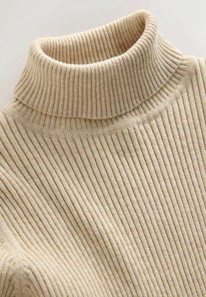 Beige bordás garbó pulóver, amely magas gallérral és textúrált kötött kialakítással rendelkezik, hangsúlyozva a függőleges csíkokat és egy puha, rugalmas anyagot.