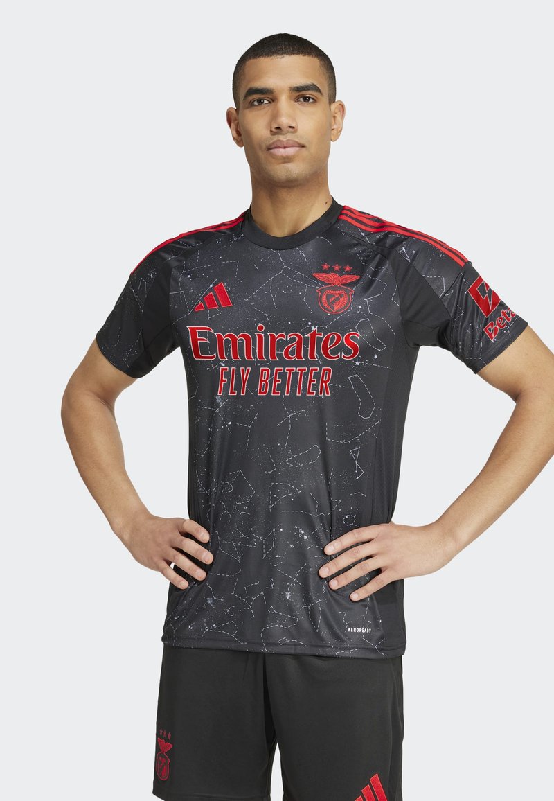 Juodasis trumpomis rankovėmis futbolo marškinėliai su raudonomis detalėmis ir "Emirates" logotipu, su žvaigždžių konsteliacijų raštu. Su jais derinamos juodos šortai.