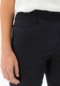 Nasselblauen Pants mit weichem Griff, elastischem Bund und Fronttaschen-Details, versehen mit kontrastierenden Nähten entlang der Nähte.