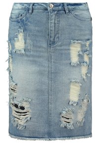 Jupe en denim bleu clair, présentant plusieurs patchs usés, des bords effilochés, une fermeture à boutons, et deux poches avant.
