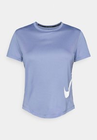 Jasnofioletowa koszulka sportowa z okrągłym dekoltem, krótkimi rękawami i zaokrąglonym hemem. Posiada białe logo Nike z boku. Miękka tekstura materiału.