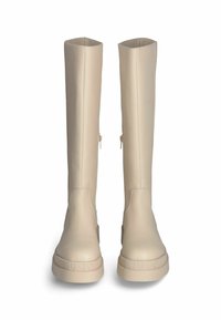 Stivali beige fino al ginocchio realizzati in materiale sintetico liscio, con punta rotonda, suola piatta e dettaglio della cerniera laterale. Marchio sulla suola.