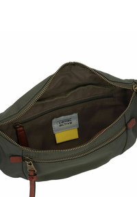 Olijfgroene tas met een ritssluiting, binnenzak en tanleren accenten. Voorzien van een merklabel en een gladde, gestructureerde stof.