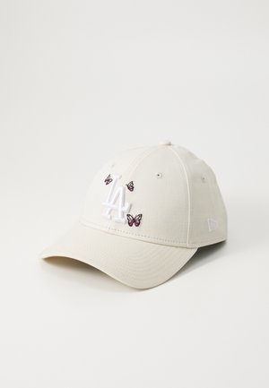 Beige Basecap mit einem aufgestickten weißen "LA"-Logo und kleinen pinken Schmetterlingsdesigns auf der Vorderseite. Aus Baumwollstoff gefertigt.