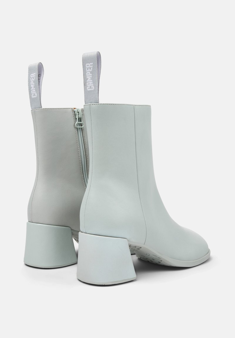 Lichtblauwe enkellaarzen van glad leer, voorzien van een zijrits en een brede, hoekige hak. Heeft lusvormige stoffen tabs voor gemakkelijk aantrekken.