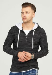 Schwarz- und grau gestreiftes Langarm-Hoodie mit weißen Kordeln und einer hellgrauen Innenkapuze. Verfügt über eine knöpfbare Blende und enganliegende Bündchen.