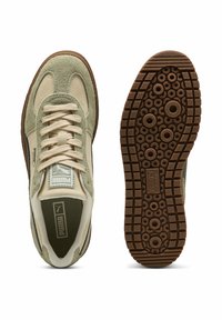 Sneakers in suede verde e beige con suola in gomma caratterizzata da motivi circolari. Dotate di lacci e con un logo PUMA prominente sulla linguetta.