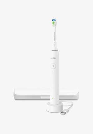 Weiße Philips Sonicare elektrische Zahnbürste, die auf einer runden Ladestation mit USB-Kabel steht und dahinter ein geschlossenes Reiseetui.