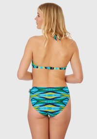Bikini avec un design de cou Halter en motifs géométriques bleus, verts et jaunes. Il dispose d'un bas taille basse et de bretelles ajustables.