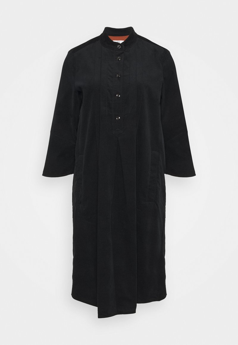 Cappotto lungo nero con collo alla mandarina, chiusura frontale con bottoni, due tasche laterali e un tessuto liscio e testurizzato.