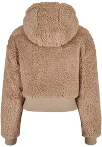 Afskåret hoodie i lys beige, lavet af blød, tekstureret stof. Har en hætte og ribbede mansjetter med en glat kant.