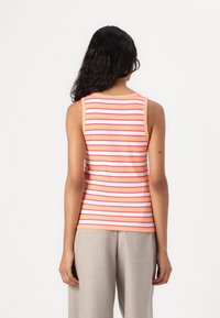 Sleeveless striped tank top featuring alternating coral and white stripes, crafted from a soft, textured fabric. Rounded neckline and fitted silhouette.