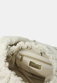 Borsa a secchiello bianca in pelle con apertura arricciata, hardware dorato e tasca interna con cerniera. Presenta una placca con logo e una texture liscia e morbida.