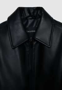 Giubbotto in pelle sintetica nera con colletto, chiusura con zip e texture liscia. All'interno è visibile l'etichetta del marchio "CALLIOPE," taglia segnata come small.