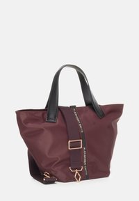 Borsa a tracolla bordeaux con manici neri, chiusura con zip e tracolla staccabile. Presenta minuteria color oro e un logo decorativo. Texture liscia.