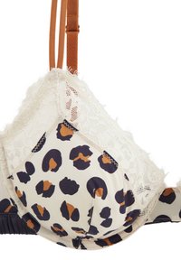 Soutien-gorge à motif léopard avec une bordure en dentelle crème, des bretelles marron réglables et une texture douce. Détails remarquables comprenant une couture en zigzag le long des bords.