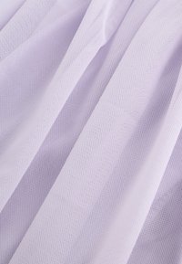 Tissu en mesh texturé violet clair avec des plis diagonaux doux créant un effet drapé délicat.