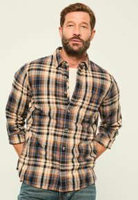 Herren Karohemd aus Baumwollstoff, mit orange, marineblau, beige und grauen Farbtönen. Knopfverschluss-Design mit legerem Schnitt und hochgekrempelten Ärmeln.