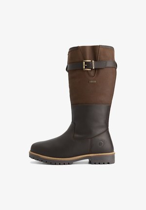 Hoge bruine leren laars met een gestructureerde bovenkant, een donkere gladde onderkant, een gouden gespstrap nabij de bovenkant en een robuuste zoolprofiel.