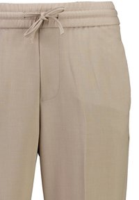 Beżowe spodnie casualowe z elastycznym pasem i wiązaniem, z bocznymi kieszeniami i subtelnymi detalami w postaci przeszyć.