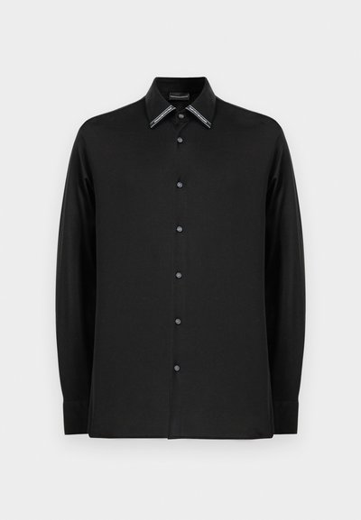 Μαύρο μπλουζάκι με μακριά μανίκια φτιαγμένο από μαλακό ύφασμα, με ανθεκτικό γιακά και αντίθετους τόνους και κουμπιά μπροστά. Απλός σχεδιασμός.