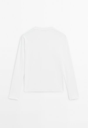 Simpel hvid langærmet skjorte, rund hals, vist fra ryggen, lagt fladt på en hvid baggrund.