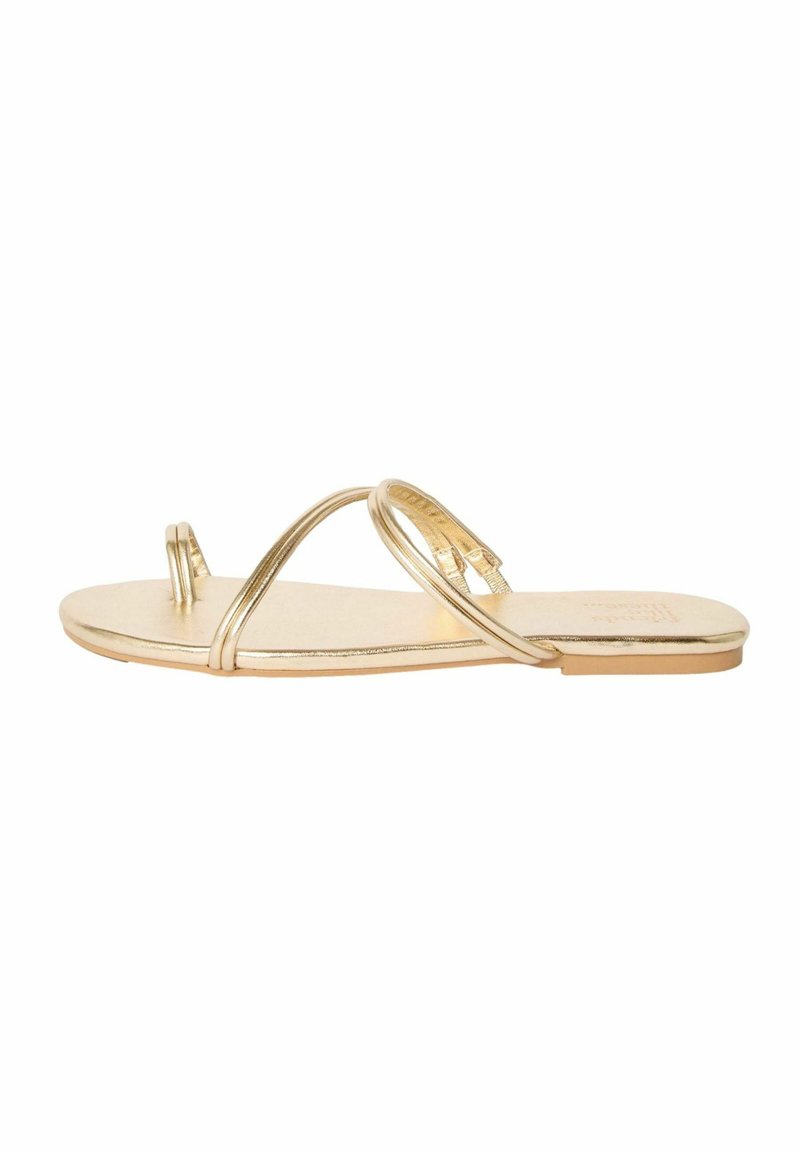 Gouden platte sandaal met dunne banden en cirkelvormige accenten. De zool is glad met een glanzende metallic afwerking en een minimalistisch ontwerp.