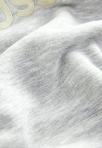 Gray cotton fabric with a soft texture, featuring subtle variations in color. Smooth surface with a slight sheen, ideal for casual wear.