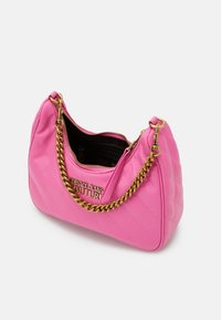 Rosa kviltad handväska med en kedjestrand i guld, dragkedja upptill och logotypdetalj på framsidan. Slät textur med rundad form.