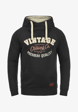 Črna kapuca s vrvico, kenguru žepom in grafično besedilo v kremni vintage slogu. Ima rebraste manšete in spodnji rob.