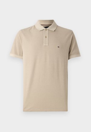 Beige polo shirt made of cotton with a smooth texture, featuring a three-button placket and a small embroidered logo on the chest.