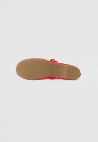 Rød sandal med en teksturert overdel, mønstret design og en lys brun gummisåle med horisontale spor for grep.