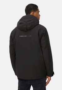 Schwarze isolierte Jacke mit Kapuze, ausgestattet mit einem reflektierenden Streifen auf dem Rücken und strukturiertem Stoff. Lässiges Design mit verstellbaren Manschetten.