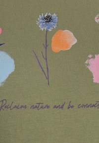 Tejido verde oliva con una textura acanalada que presenta estampados florales coloridos en azul, naranja, rosa y púrpura. Texto: "Recupera la naturaleza y mantente conectado."