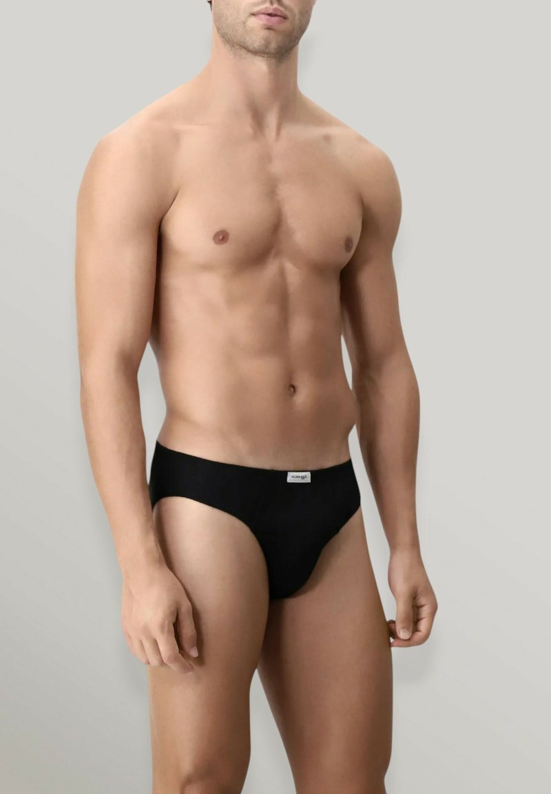 Slip bikini in cotone nero con etichetta bianca in vita, caratterizzati da un design aderente e una texture liscia.