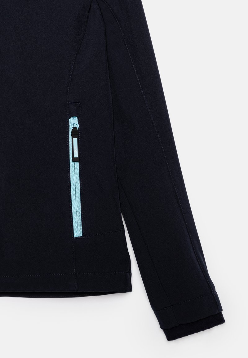 Veste navy avec une poche latérale zippée dotée d'un zip bleu clair. Tissu doux et texturé, avec des poignets ajustés en polaire foncée.