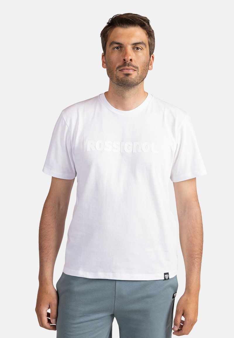 Biała bawełniana koszulka z krótkim rękawem, z okrągłym dekoltem, ozdobiona wypukłym, teksturowanym nadrukiem słowa "ROSSIGNOL" na przodzie.
