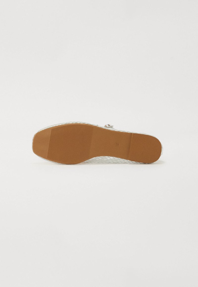 Semelle de chaussure transparente avec un motif en nid d'abeille, dotée d'une base en caoutchouc beige, texturée pour une meilleure adhérence et un bon soutien. Design minimaliste, style fonctionnel.