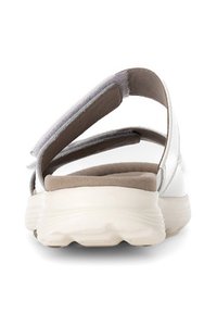 Witte sandaal met verstelbare banden en een gevoerde beige voetbed. Heeft een ronde, lichte zool voor comfort en stabiliteit.